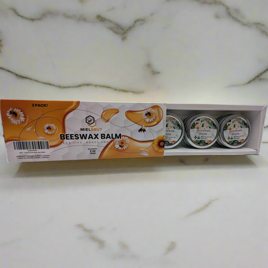 A 3-pack of Mielbrut.com beeswax balms rests on a marble surface, highlighting natural benefits. The packaging, with bee and flower imagery, contains three small tins perfect for skin hydration, emphasizing use for dry skin and lips.