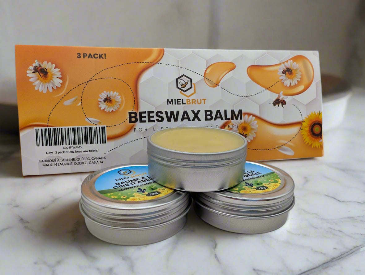 Three tins of beeswax balm from Mielbrut.com are displayed in front of packaging labeled "3 pack beeswax balms for your lips and skin," promising natural hydration benefits. The floral and bee-adorned packaging rests on a reflective silver surface.
