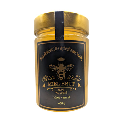 A jar of Beekeeper's Special Reserve: Exceptional Catalpa Honey from Mielbrut.com, featuring a golden lid and a black label. The label showcases a central bee illustration, surrounding text in French, and specifies that the honey is “Non Pasteurisé” (non-pasteurized) and “100% Naturel.” This limited edition jar contains 450 grams.