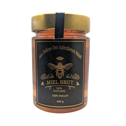 A 450g jar of "Saffron Elixir: Pure Quebec Honey Infused with the Golden Essence of Iranian Saffron" by Mielbrut.com, unpasteurized and 100% natural, features a golden lid and black label adorned with a bee illustration.