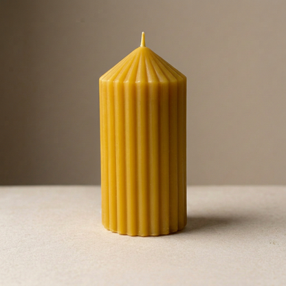 Golden ribbed beeswax pillar candle with a pointed top